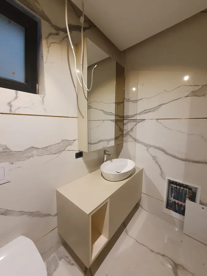 Baie marmură albă, lavoar bej suspendat, oglindă — mobilier de baie la comandă Fine Cut Furniture, Arad