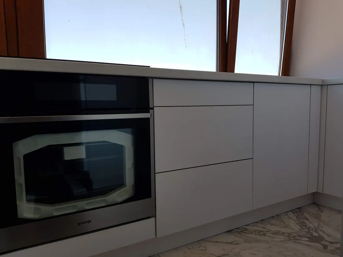 Bucătărie gri deschis fără mânere, pardoseală marmură — bucătărie la comandă Fine Cut Furniture, Timișoara