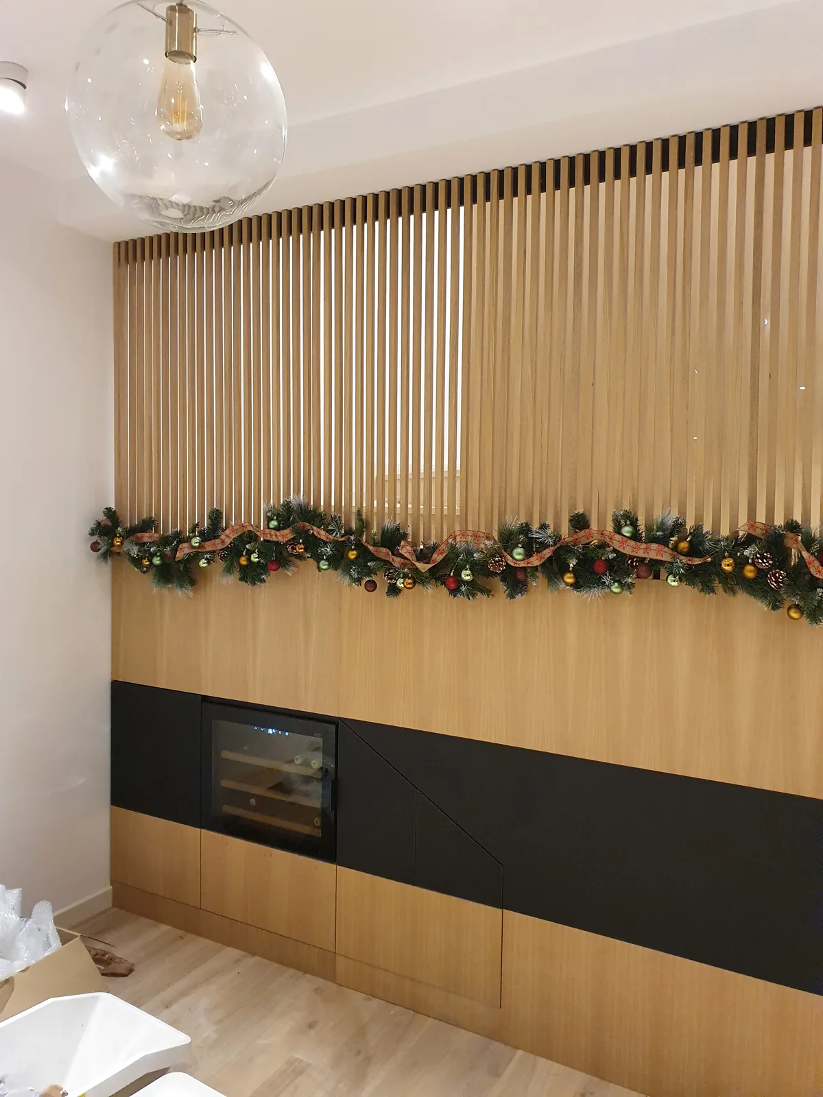 Perete cu lamele din lemn și corpuri joase negre — bucătărie la comandă Fine Cut Furniture, Orăștie