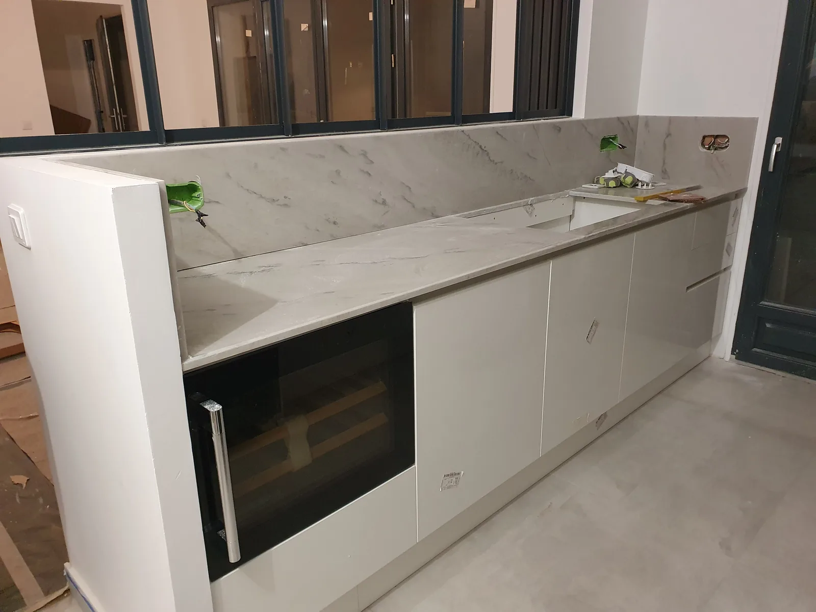 Bucătărie albă lungă cu spate din marmură și frigider de vin încorporat — bucătărie la comandă Fine Cut Furniture, Houilles, Franța