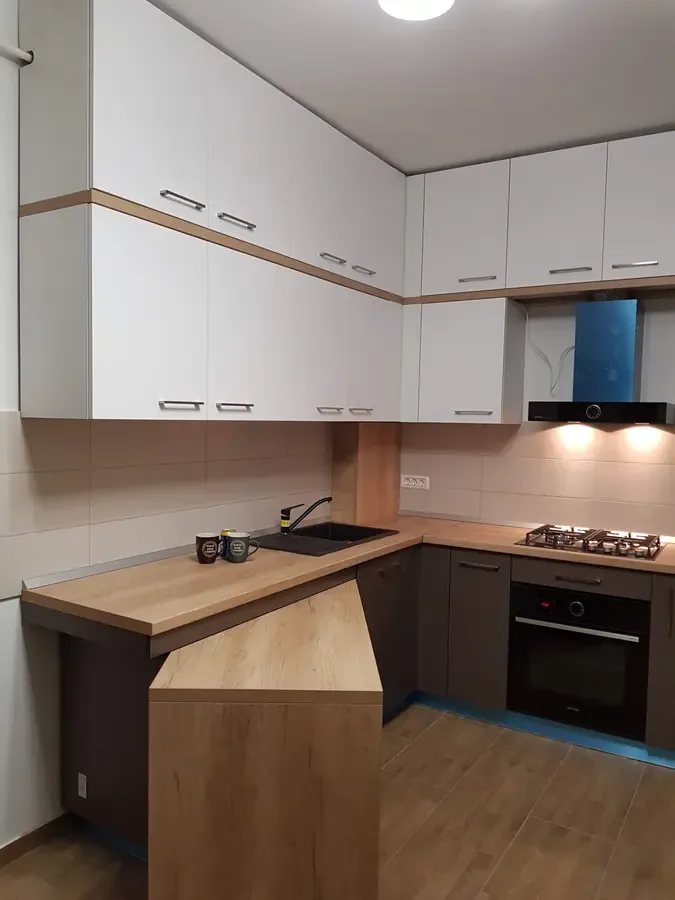 Bucătărie cu bar din lemn și corpuri inferioare închise la culoare — bucătărie la comandă Fine Cut Furniture
