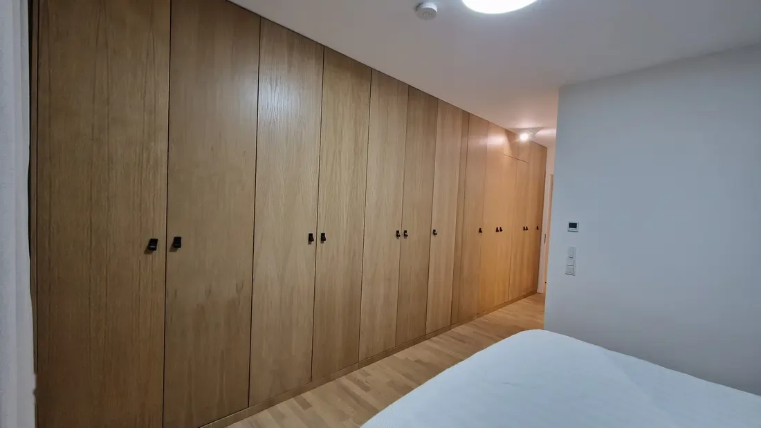 Perete dulap furnir stejar în dormitor, mânere negre — dressing la comandă Fine Cut Furniture