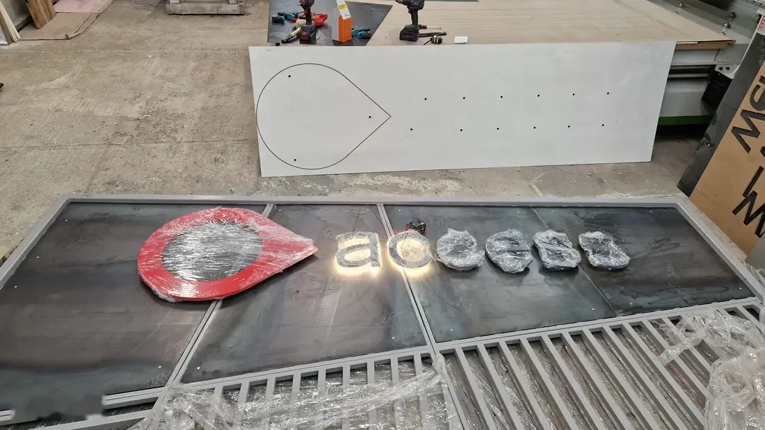 Siglă din litere volumetrice pe panou lemn închis — producție în atelierul propriu Fine Cut Furniture